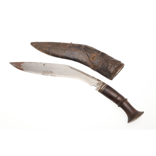 69 - A KUKRI KNIFE AND SCABBARD. With a traditionally shaped 25 cm pointed blade on a hardwood handle. In... 