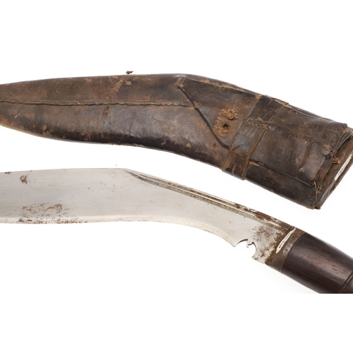 69 - A KUKRI KNIFE AND SCABBARD. With a traditionally shaped 25 cm pointed blade on a hardwood handle. In... 