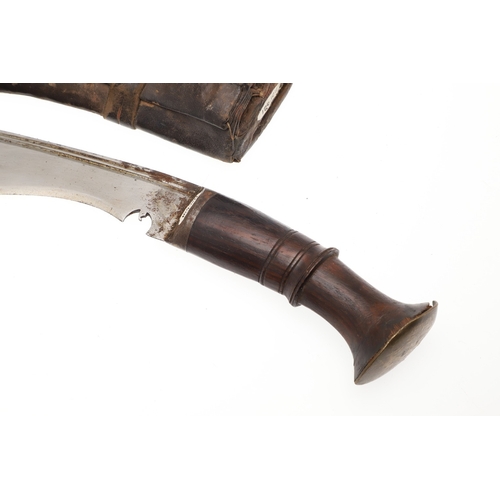 69 - A KUKRI KNIFE AND SCABBARD. With a traditionally shaped 25 cm pointed blade on a hardwood handle. In... 
