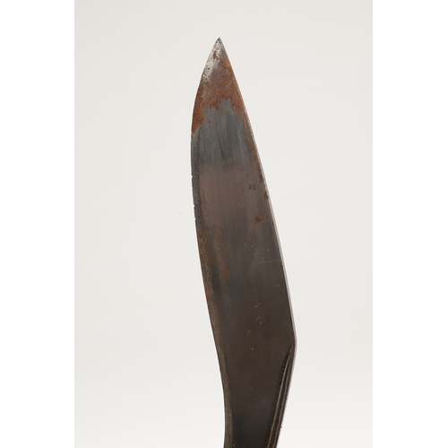 69 - A KUKRI KNIFE AND SCABBARD. With a traditionally shaped 25 cm pointed blade on a hardwood handle. In... 