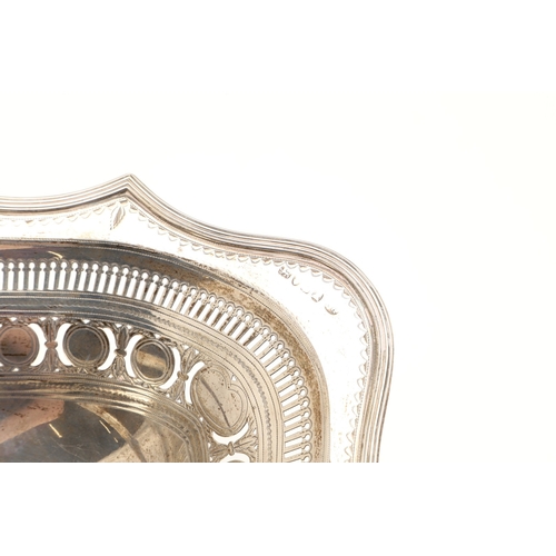 24 - A GEORGE III SILVER CAKE OR BREAD BASKET. Of shaped oval form with a reeded border, pierced and engr... 