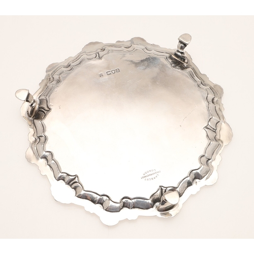 31 - A LATE VICTORIAN SILVER SALVER. Of circular form with shell and scroll raised border edge, standing ... 