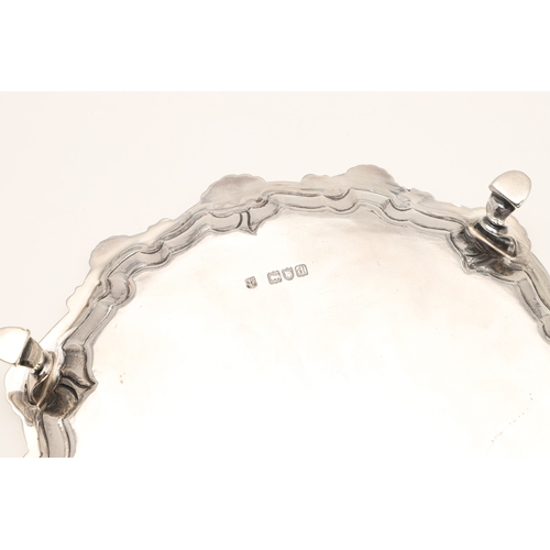 31 - A LATE VICTORIAN SILVER SALVER. Of circular form with shell and scroll raised border edge, standing ... 