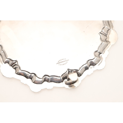 31 - A LATE VICTORIAN SILVER SALVER. Of circular form with shell and scroll raised border edge, standing ... 