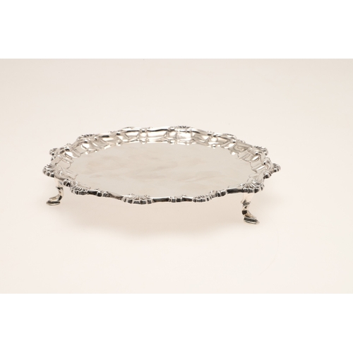 31 - A LATE VICTORIAN SILVER SALVER. Of circular form with shell and scroll raised border edge, standing ... 