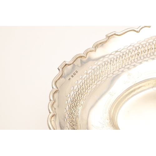 36 - AN EDWARDIAN SILVER TABLE BASKET. Of oval form with shaped border, pierced design and engraved decor... 