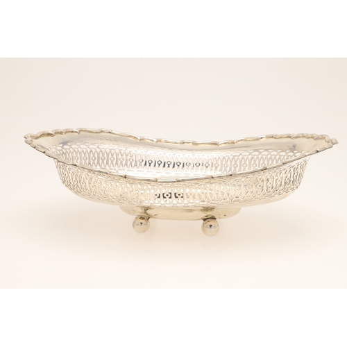 36 - AN EDWARDIAN SILVER TABLE BASKET. Of oval form with shaped border, pierced design and engraved decor... 