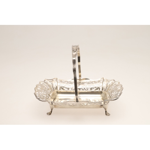 37 - AN EDWARDIAN SILVER BASKET. With pierced foliate design sides and to the movable handle, raised on f... 