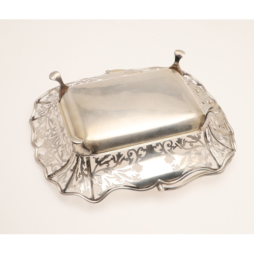 37 - AN EDWARDIAN SILVER BASKET. With pierced foliate design sides and to the movable handle, raised on f... 