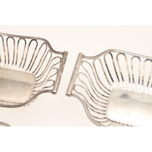 40 - A SET OF FOUR EDWARDIAN SILVER BON BON DISHES. Of shaped rectangular form with wirework style decora... 