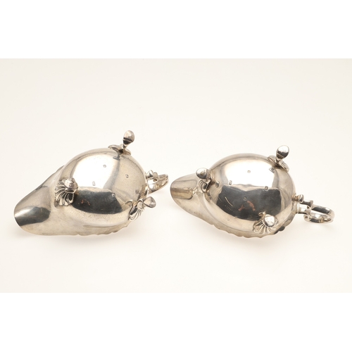 44 - A PAIR OF SILVER SAUCE BOATS. With card cut border, scroll handle and stood on three hoofed feet. Ha... 