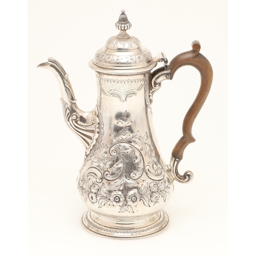 47 - AN EARLY GEORGE III SILVER COFFEE POT. With chased floral and foliate decoration, scroll handle and ... 