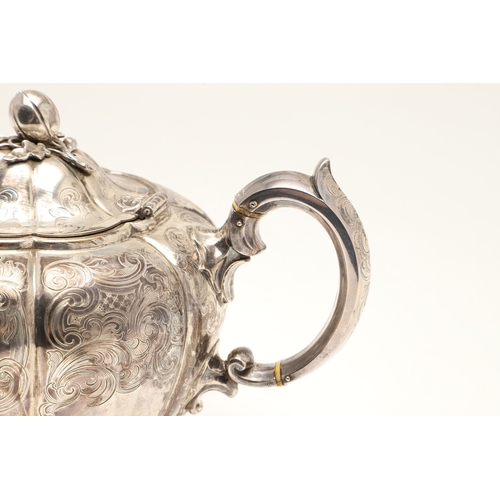 49 - A VICTORIAN ENGRAVED SILVER TEAPOT. Of melon form with engraved foliate scrolls, crested and initial... 