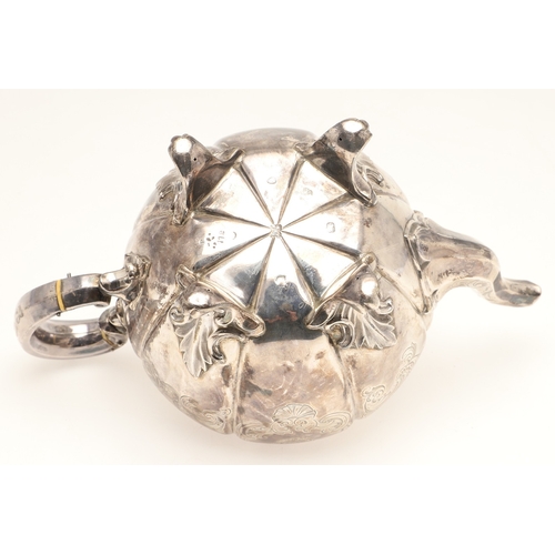 49 - A VICTORIAN ENGRAVED SILVER TEAPOT. Of melon form with engraved foliate scrolls, crested and initial... 