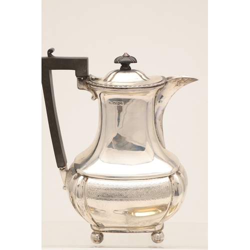 52 - AN EDWARDIAN SILVER FOUR PIECE TEA SET. Of shaped oblong form, with engraved foliate decoration, gad... 