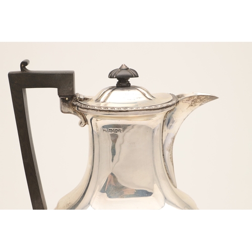 52 - AN EDWARDIAN SILVER FOUR PIECE TEA SET. Of shaped oblong form, with engraved foliate decoration, gad... 