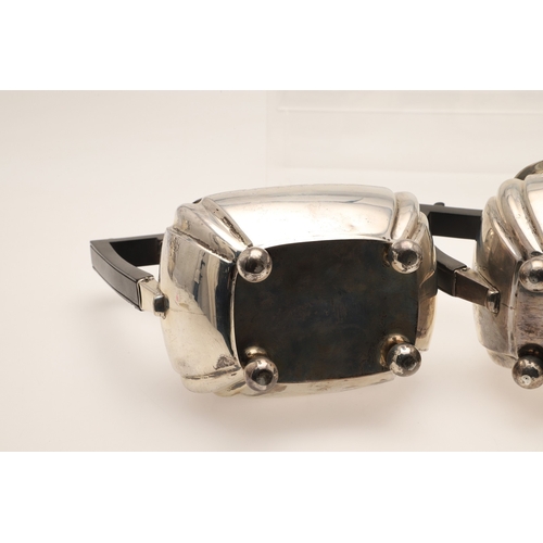 52 - AN EDWARDIAN SILVER FOUR PIECE TEA SET. Of shaped oblong form, with engraved foliate decoration, gad... 