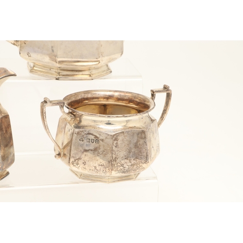 53 - AN EDWARDIAN SILVER FOUR PIECE OCTAGONAL FORM TEA SET. Comprising teapot and hot water/coffee pot, b... 
