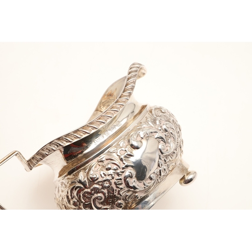 54 - A GEORGE V SILVER THREE PIECE TEA SET. Each of shaped oblong form, gadrooned rims over bands of repo... 