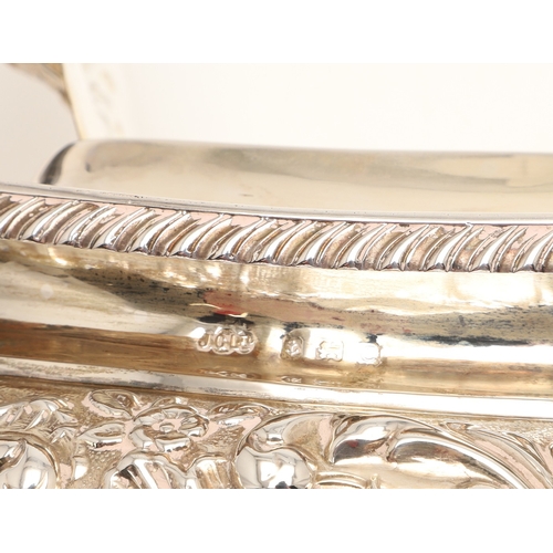 54 - A GEORGE V SILVER THREE PIECE TEA SET. Each of shaped oblong form, gadrooned rims over bands of repo... 