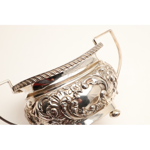 54 - A GEORGE V SILVER THREE PIECE TEA SET. Each of shaped oblong form, gadrooned rims over bands of repo... 
