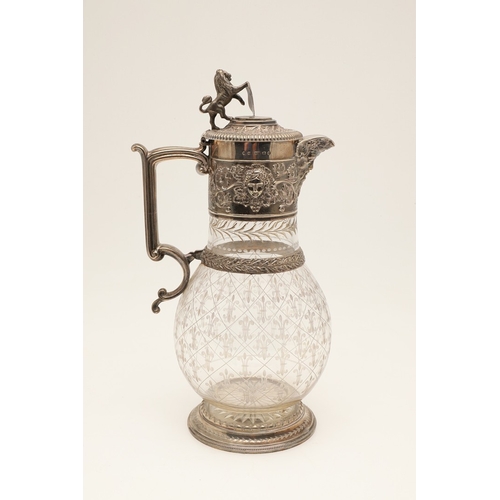 62 - A VICTORIAN SILVER MOUNTED GLASS CLARET JUG. Of bulbous form, the top with foliate vine and mask dec... 