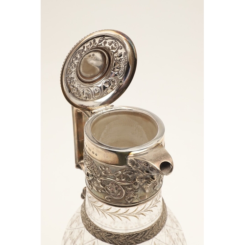 62 - A VICTORIAN SILVER MOUNTED GLASS CLARET JUG. Of bulbous form, the top with foliate vine and mask dec... 