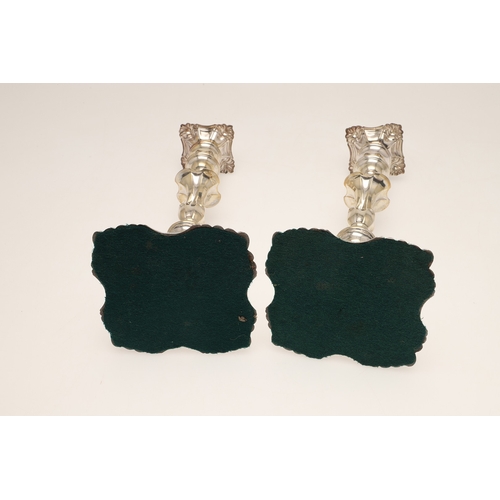 66 - A PAIR OF LATE VICTORIAN SILVER CANDLESTICKS. On shaped square bases (loaded), with knopped stems an... 