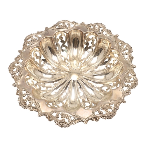 69 - A DECORATIVE EDWARDIAN SILVER BON BON DISH. The shaped circular form bowl with pierced stamped folia... 