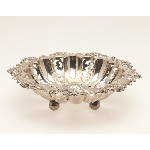 69 - A DECORATIVE EDWARDIAN SILVER BON BON DISH. The shaped circular form bowl with pierced stamped folia... 