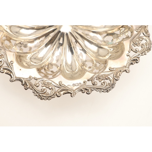 69 - A DECORATIVE EDWARDIAN SILVER BON BON DISH. The shaped circular form bowl with pierced stamped folia... 