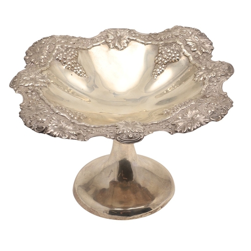 70 - AN EARLY EDWARDIAN SILVER TAZZA. With heavily embossed grape vine decoration, on a rounded base. Hei... 