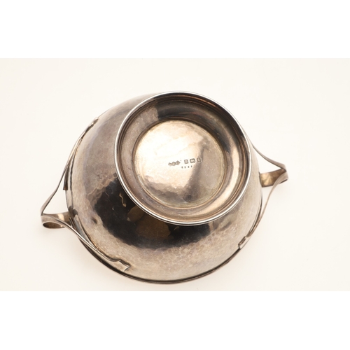 72 - AN EARLY 20TH CENTURY LIBERTY & CO SILVER BOWL. Of round form with hammered finish and twin loop han... 