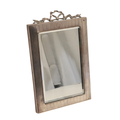 73 - A LATE EDWARDIAN SILVER EASEL DESK MIRROR. The engine turned rectangular frame with inset bevelled e... 