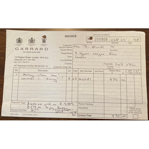 78 - A SILVER COW CREAMER BY GARRARD & CO LTD. The cow decorated with floral wreaths and insect to the li... 