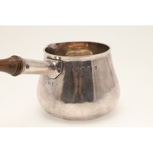 79 - A WILLIAM III BRITANNIA STANDARD SILVER SAUCE OR BRANDY PAN. With shaped wooden handle, hallmarked (... 