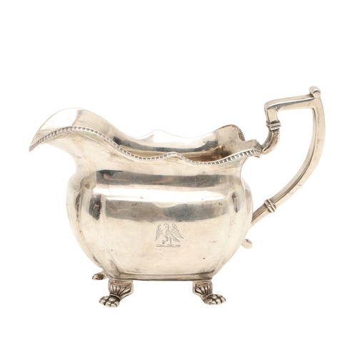 83 - A GEORGE III IRISH SILVER CREAM JUG. With gadrooned rim and stood on paw feet, engraved initials A &... 