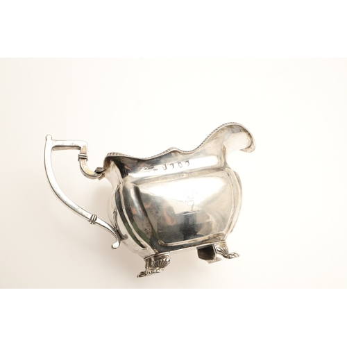 83 - A GEORGE III IRISH SILVER CREAM JUG. With gadrooned rim and stood on paw feet, engraved initials A &... 
