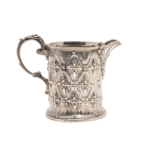 85 - A VICTORIAN SILVER JUG. Of rounded form, with repousse flowerhead decoration and scroll handle, heig... 