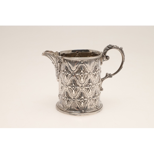85 - A VICTORIAN SILVER JUG. Of rounded form, with repousse flowerhead decoration and scroll handle, heig... 