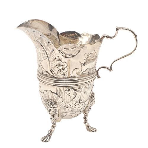 89 - A LATE VICTORIAN IRISH STYLE SILVER CREAM JUG. With later chased decoration of flora and fauna, scro... 
