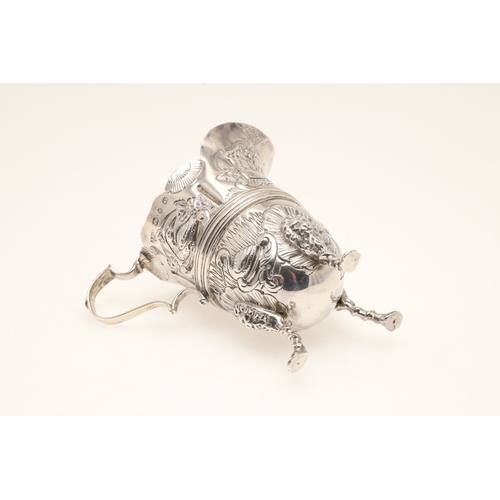 89 - A LATE VICTORIAN IRISH STYLE SILVER CREAM JUG. With later chased decoration of flora and fauna, scro... 
