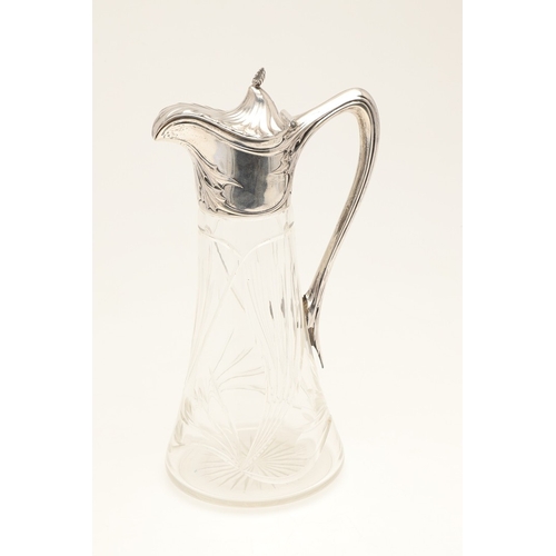 99 - A LATE 19TH CENTURY ARTS AND CRAFTS GERMAN SILVER MOUNTED GLASS CLARET JUG. An Arts and Crafts clare... 