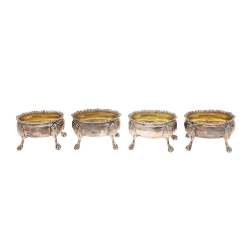 18 - A SET OF FOUR GEORGE III SILVER SALT CELLARS. Of oval form with gadrooned rim and gilded interior, t... 