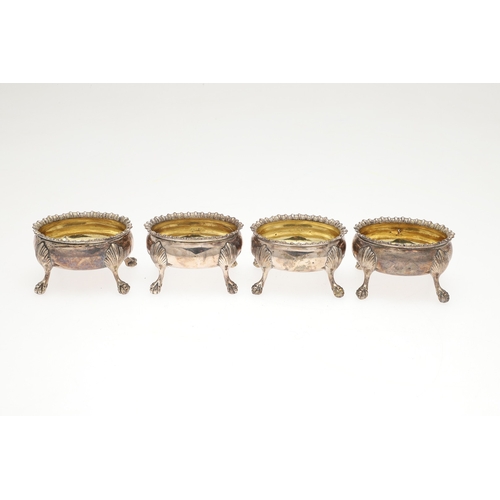 18 - A SET OF FOUR GEORGE III SILVER SALT CELLARS. Of oval form with gadrooned rim and gilded interior, t... 