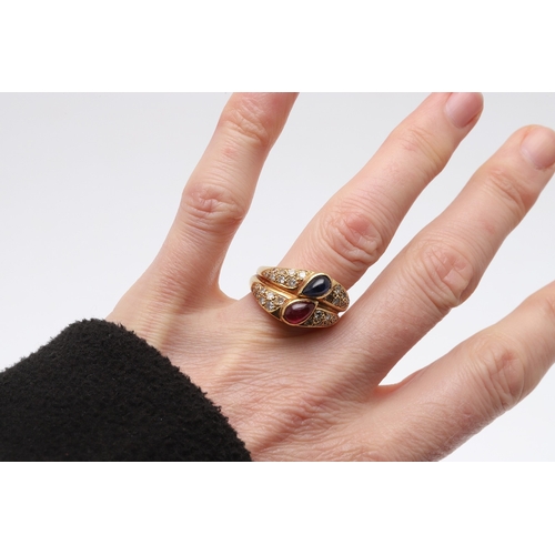 221 - A SAPPHIRE, RUBY AND DIAMOND DOUBLE BAND RING. centred with a pear-shaped ruby and sapphire cabochon... 