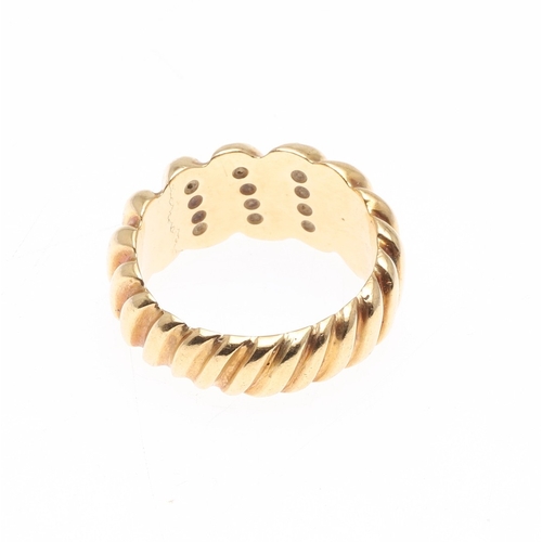224 - A DIAMOND AND GOLD RING. of graduated ridged design, mounted to the front with three rows of circula... 