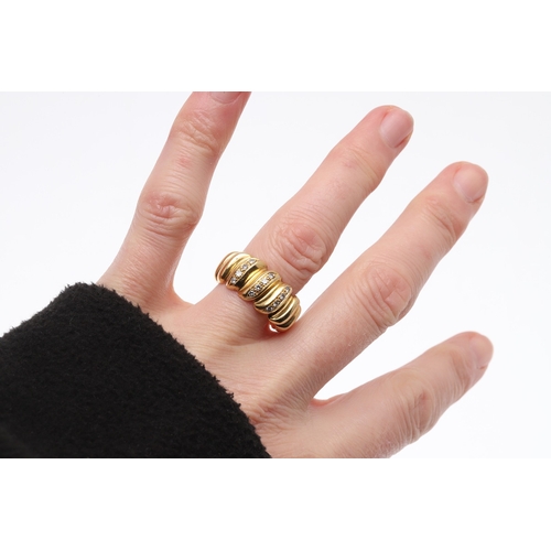 224 - A DIAMOND AND GOLD RING. of graduated ridged design, mounted to the front with three rows of circula... 