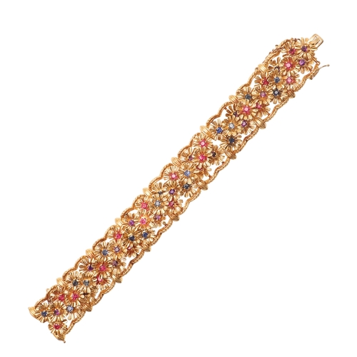 246 - A RUBY, SAPPHIRE, AMETHYST AND 18CT GOLD BRACELET BY KUTCHINSKY. the gold panel bracelet is mounted ... 