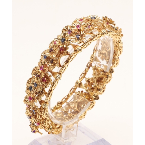 246 - A RUBY, SAPPHIRE, AMETHYST AND 18CT GOLD BRACELET BY KUTCHINSKY. the gold panel bracelet is mounted ... 